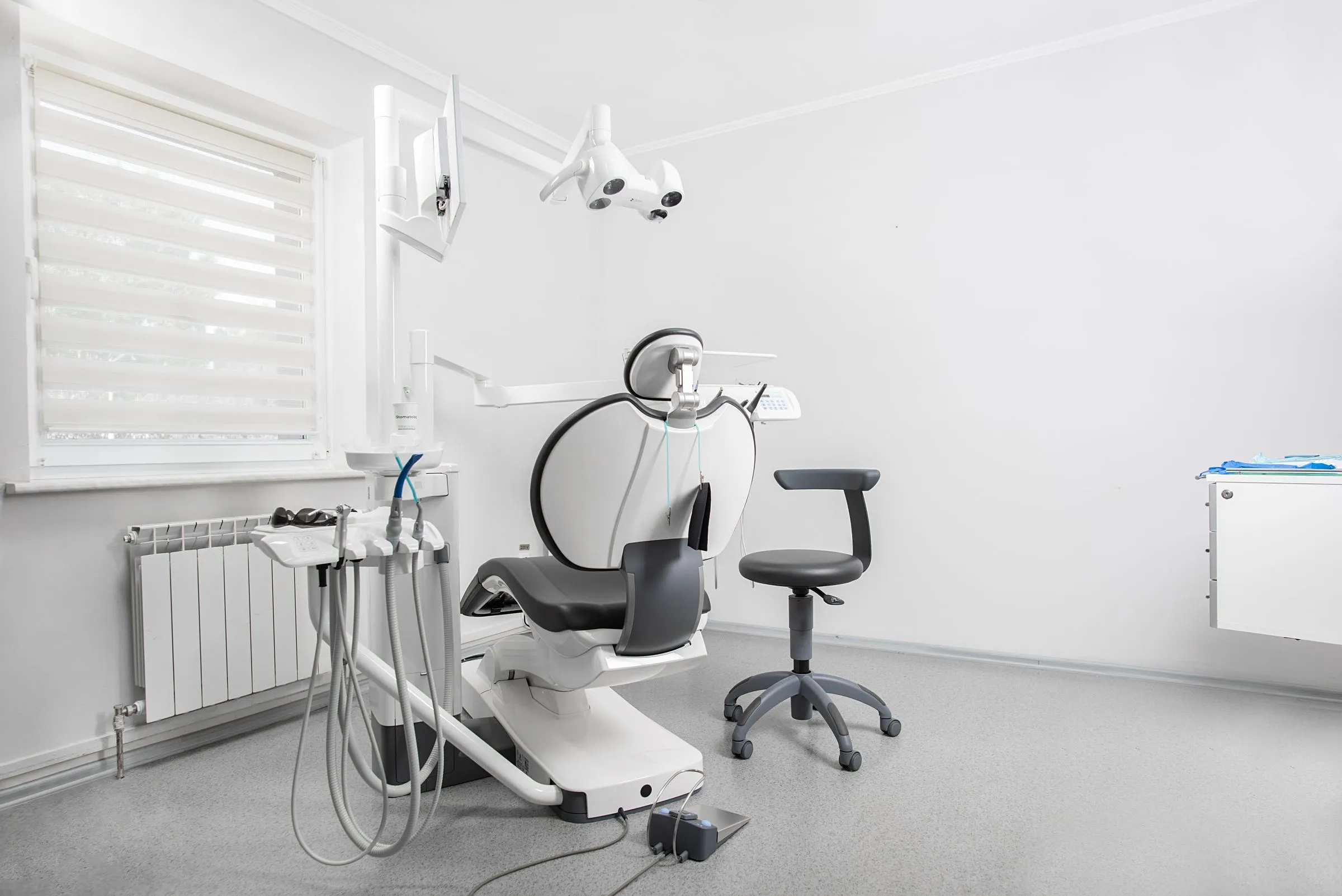 A light, airy treatment room with a dental chair and large window