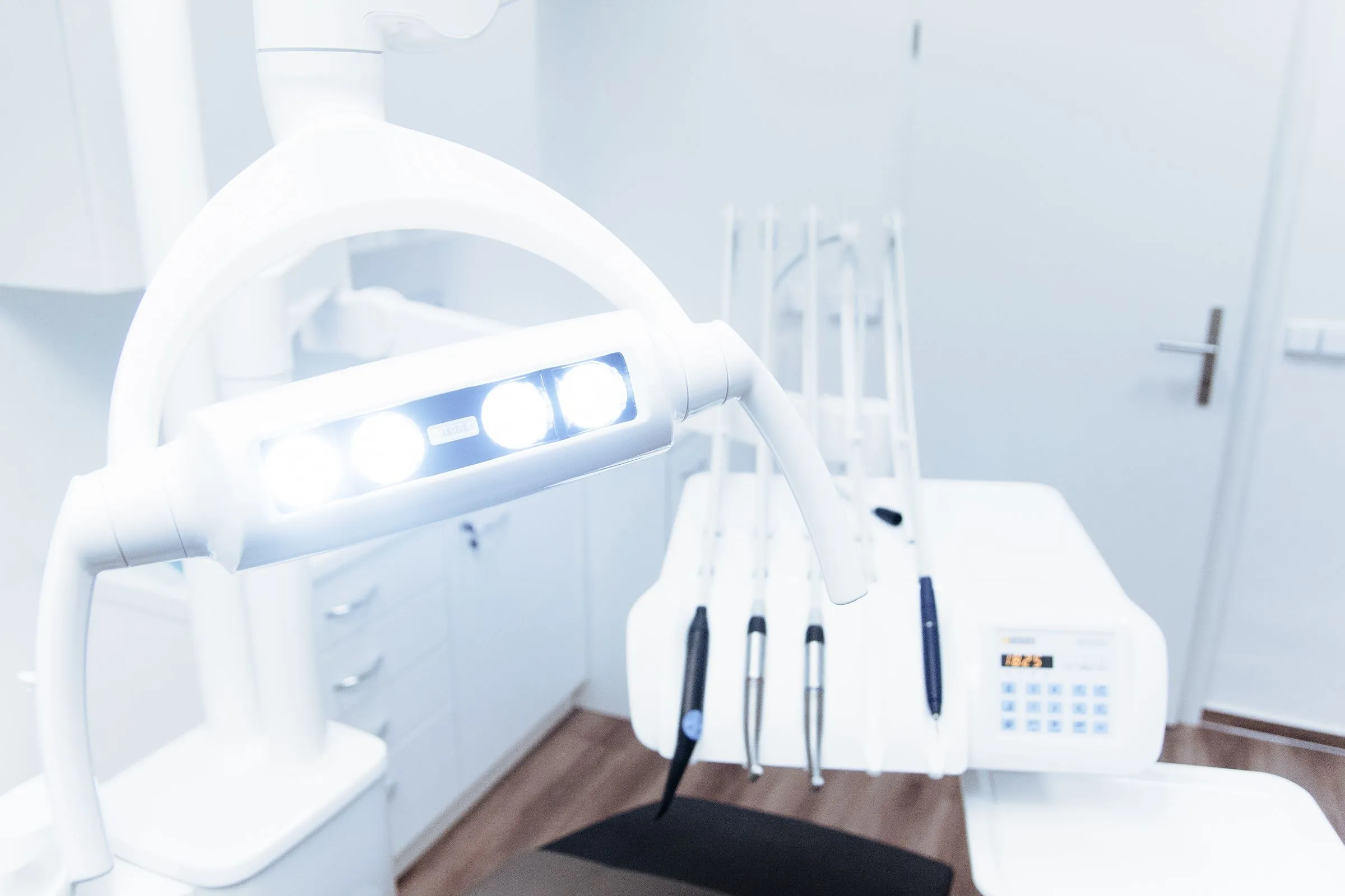 A calm, bright treatment room with a white dental chair and soft daylight